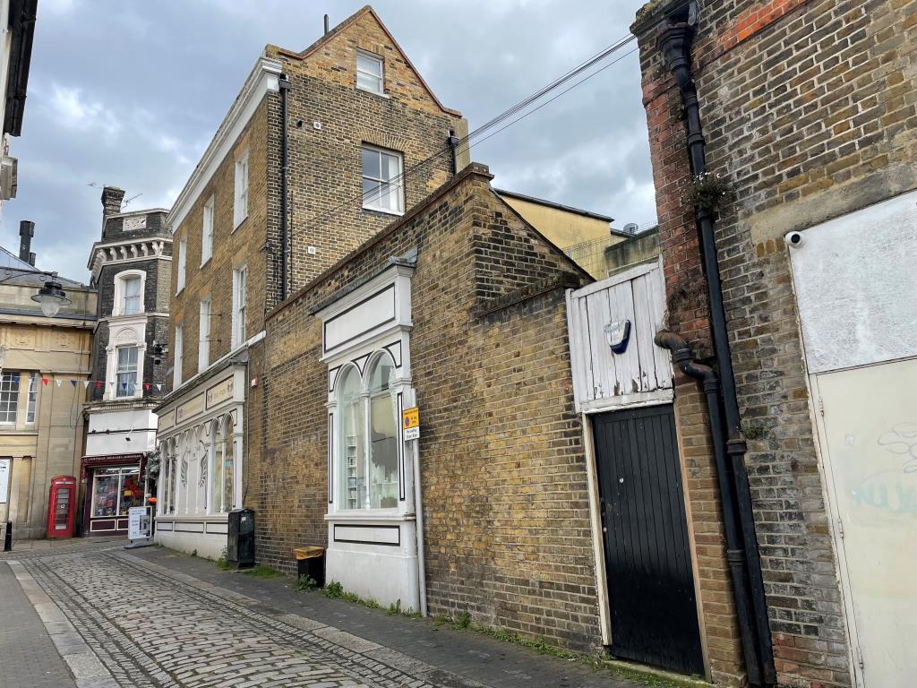 Lot: 167 - FREEHOLD COMMERCIAL INVESTMENT - Side photo of brick built building with shop on ground floor